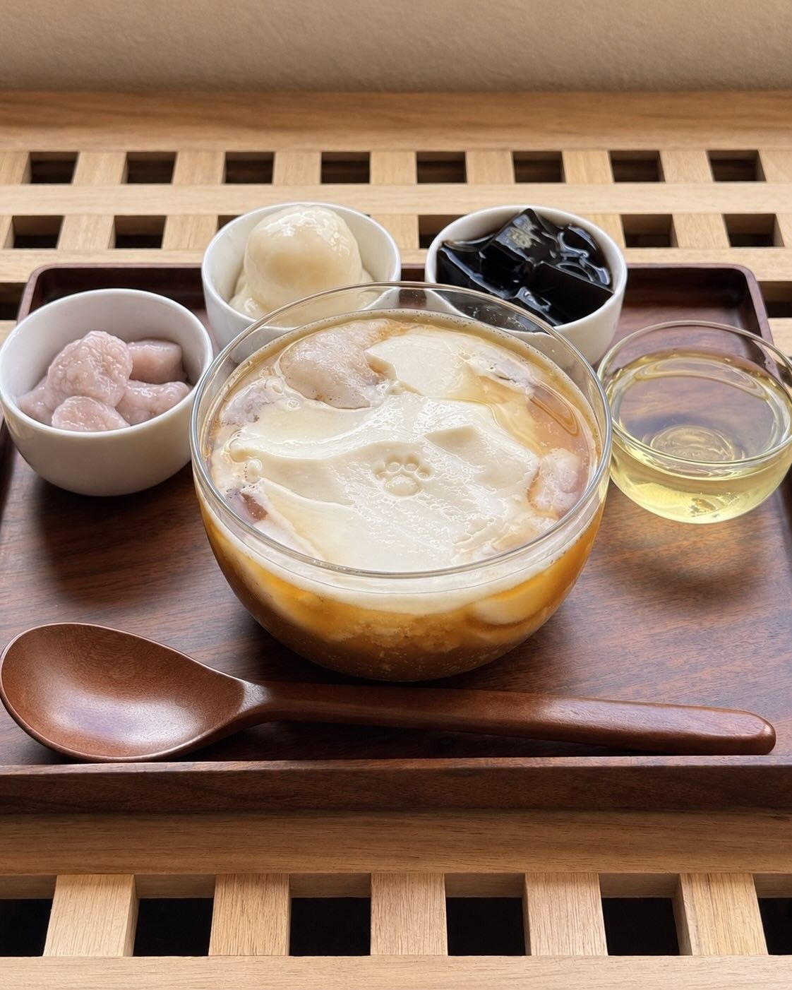 木の盆に、ガラスの器の豆花、小さな器に入ったトッピング、木の匙が並んでいる。
